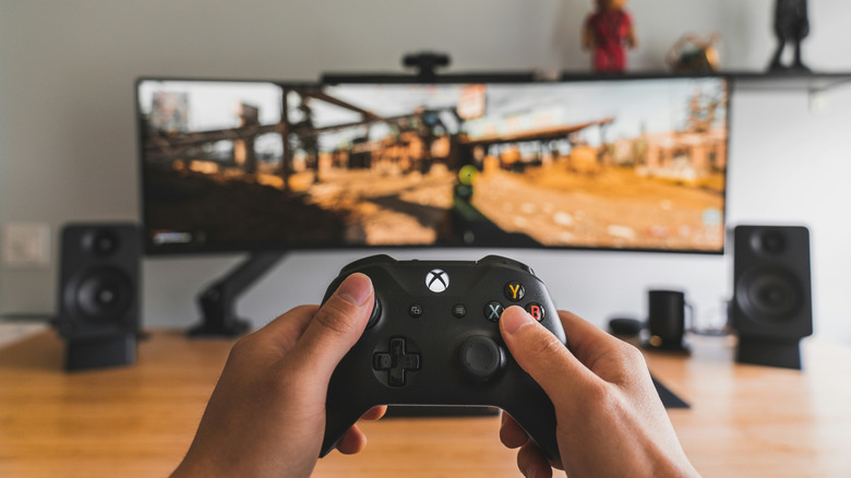 Xbox controller beside a TV showing Xbox Cloud Gaming interface, the streaming service that also depends on live Microsoft server authentication
