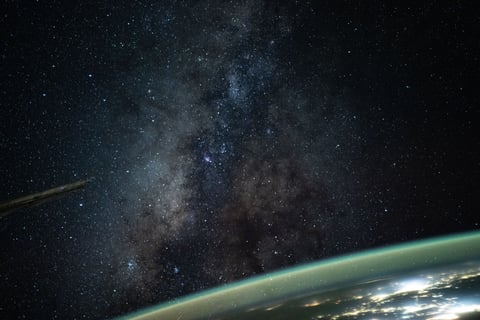 The Milky Way rises above Earth's atmospheric glow in a night sky photograph taken from the International Space Station