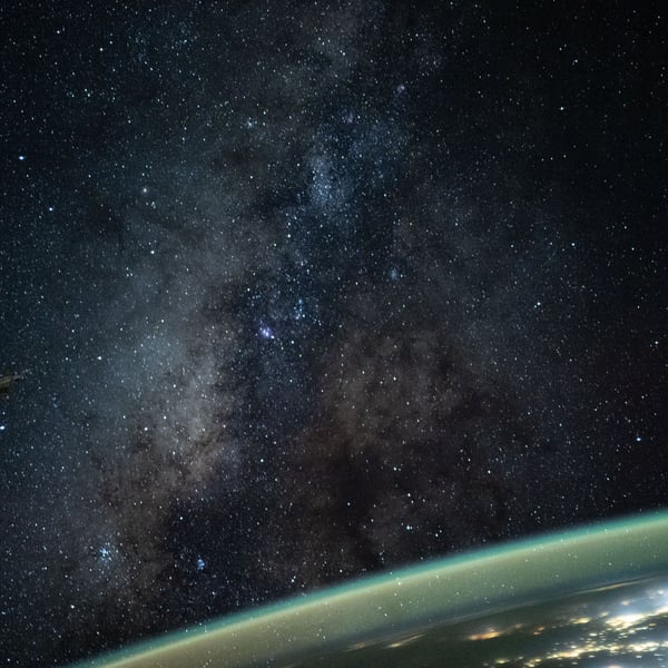 The Milky Way rises above Earth's atmospheric glow in a night sky photograph taken from the International Space Station