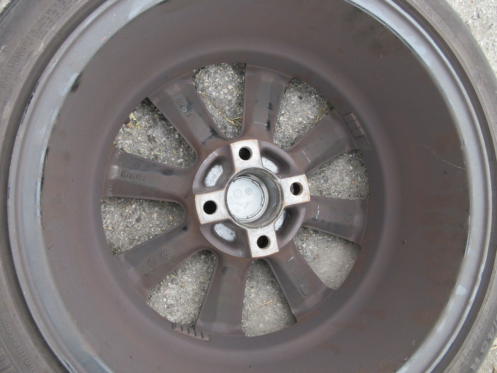 The inner barrel and spoke face of a 16-inch alloy wheel, the surface where JWL and VIA certification marks are cast into the metal