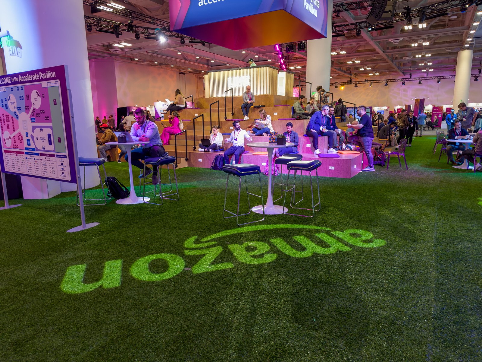 Attendees networking at the Amazon Accelerate conference innovation expo with Amazon branding visible in the background