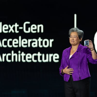 AMD CEO Lisa Su on stage holding a chip at an AMD Next-Gen Accelerator Architecture and Zen 4 presentation