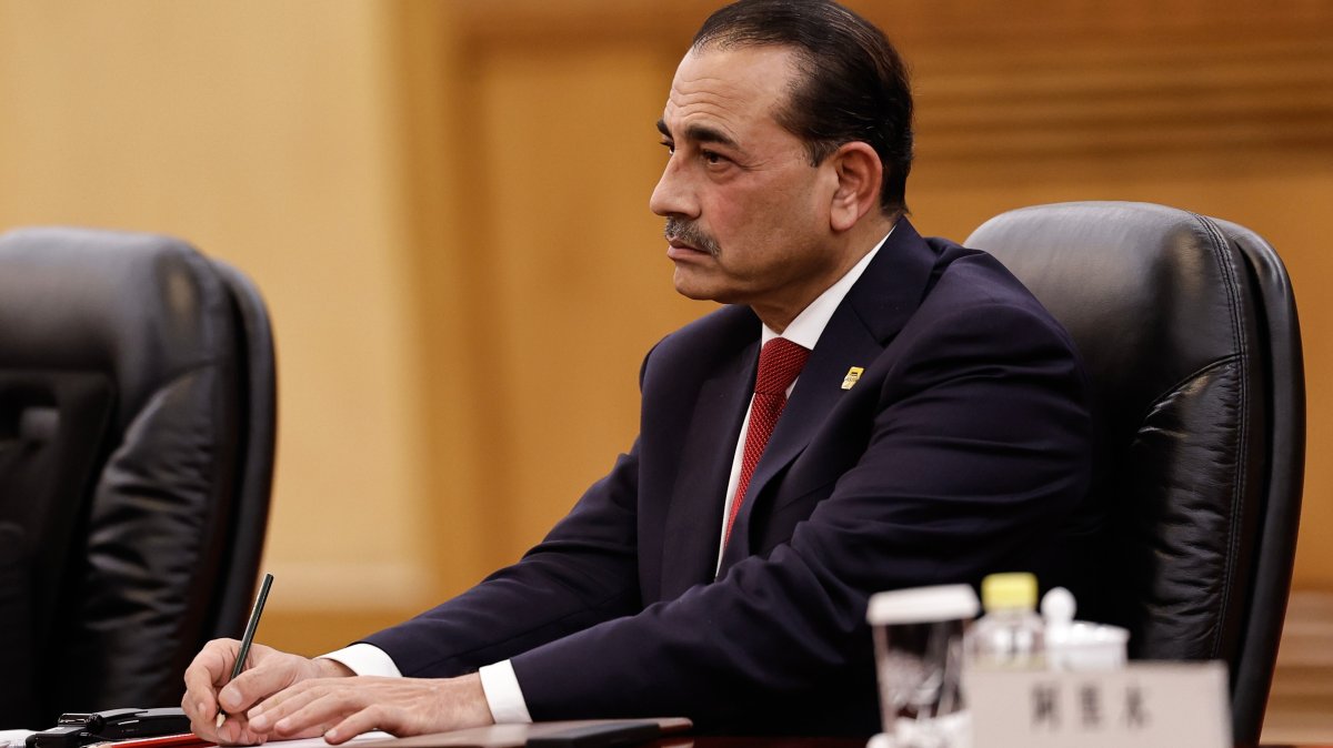 Pakistan's Field Marshal Asim Munir sits in a dark suit at an official meeting table, taking notes
