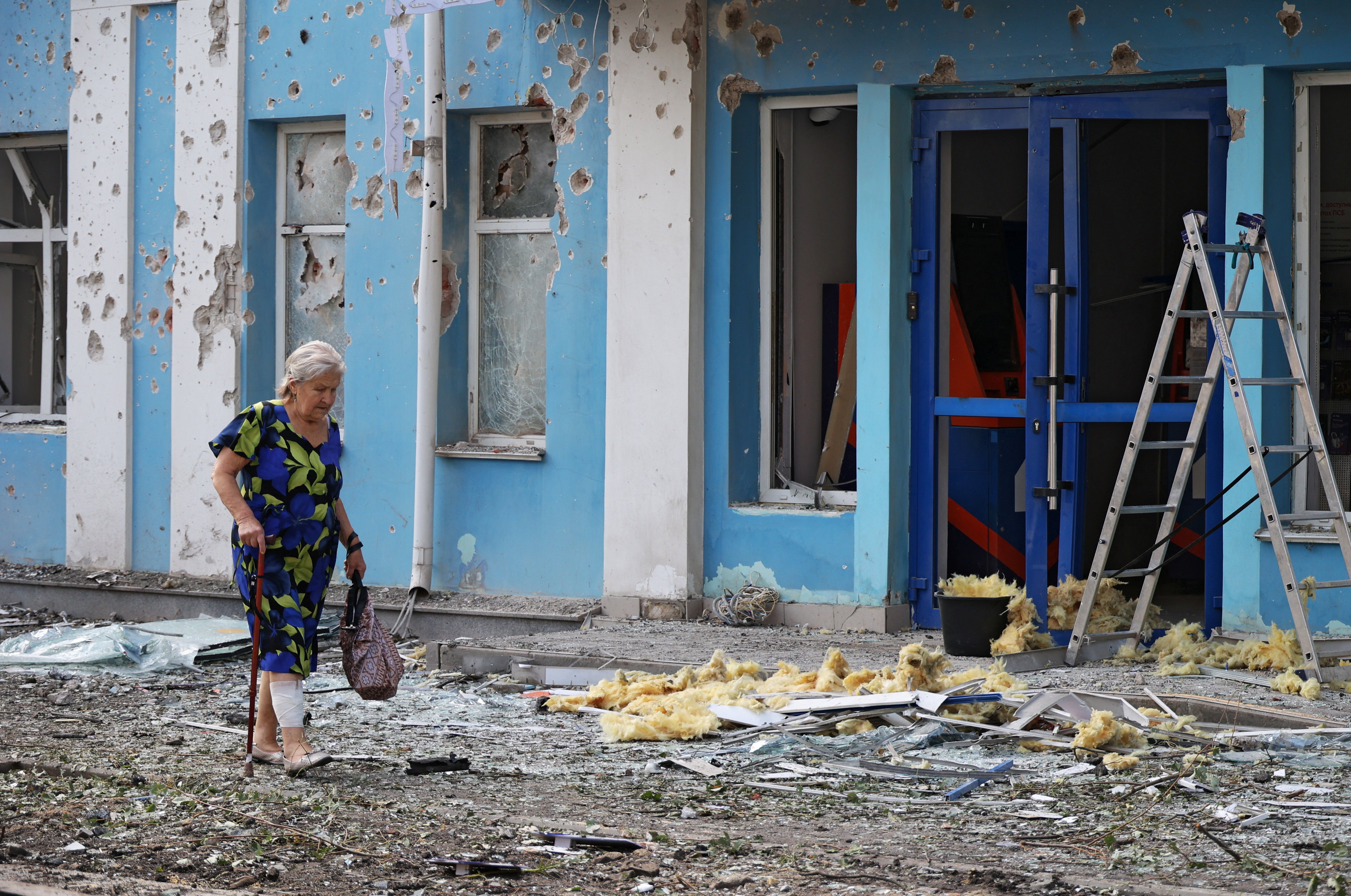 A woman walks past a damaged building in Belgorod, Russia, after a Ukrainian drone attack in August 2026 during the Ukraine war