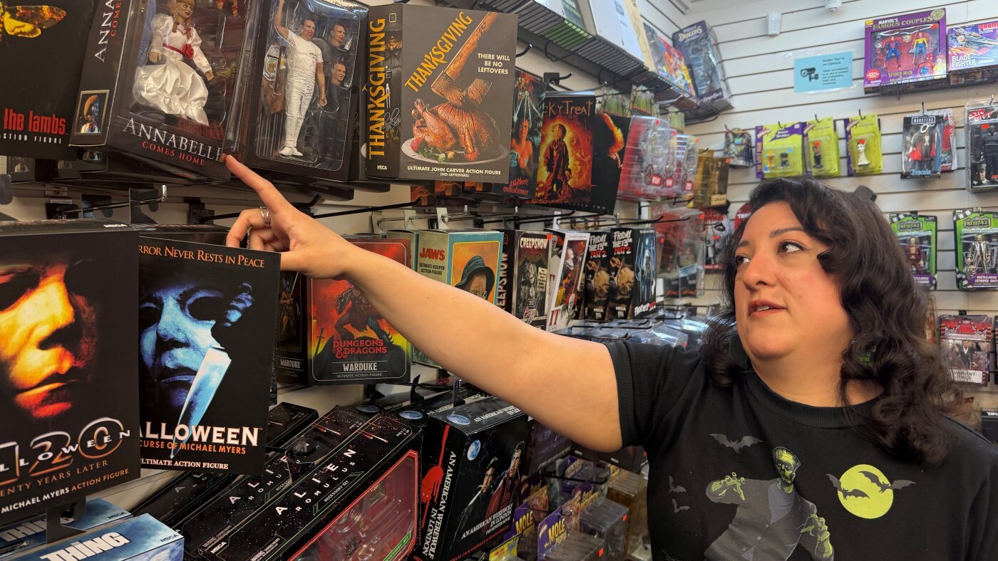 Paulina Gamino of Misfit Toys points at stock on the shelves of her independent toy shop in Houston