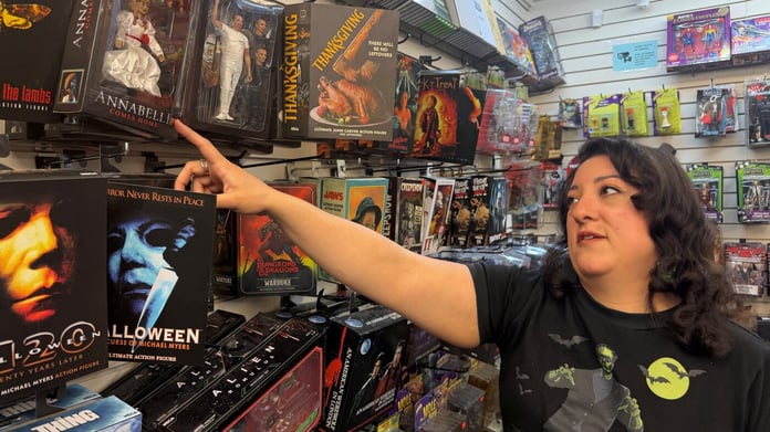Paulina Gamino of Misfit Toys points at stock on the shelves of her independent toy shop in Houston