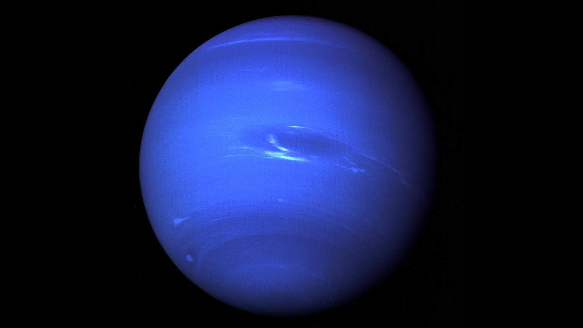 The full disc of Neptune, blue and banded with clouds, photographed by NASA's Voyager 2 spacecraft