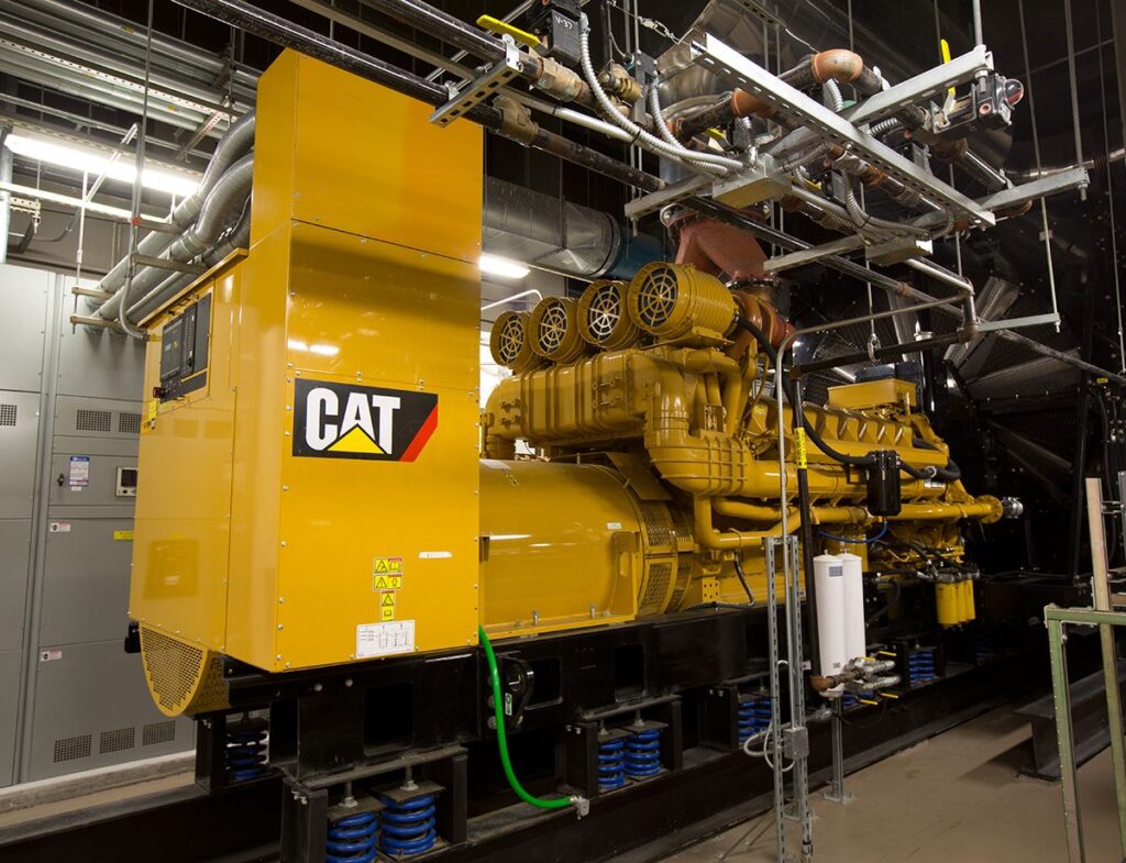 A Caterpillar generator set installed inside a data center power room providing primary power for AI infrastructure