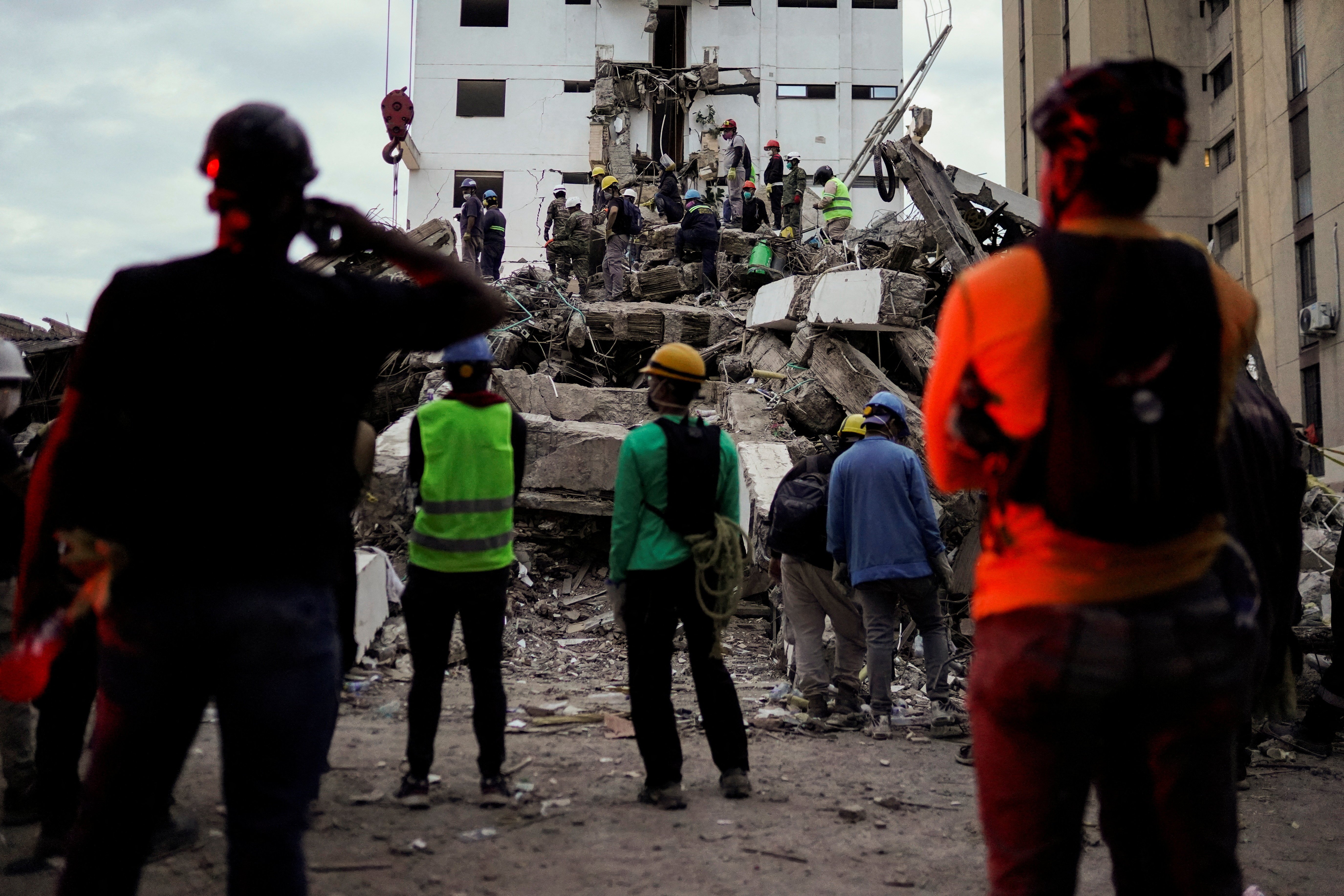 Search and rescue teams work through rubble in Cali Colombia following the 7.4 magnitude earthquake