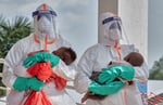 Congolese health workers in PPE examine children at Ebola response zone in Bunia, Ituri province, DRC