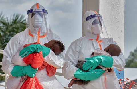 Congolese health workers in PPE examine children at Ebola response zone in Bunia, Ituri province, DRC