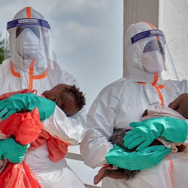 Congolese health workers in PPE examine children at Ebola response zone in Bunia, Ituri province, DRC