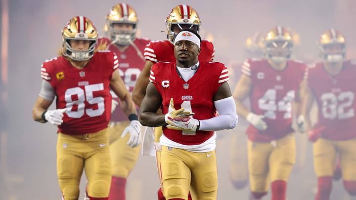 Deebo Samuel leads San Francisco 49ers players onto the field from the tunnel in red and gold uniform