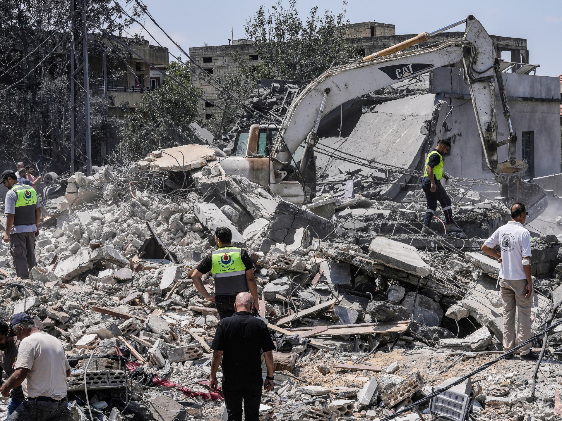 People and rescue workers gather at a destroyed house in Deir al-Zahrani in southern Lebanon after an Israeli air strike