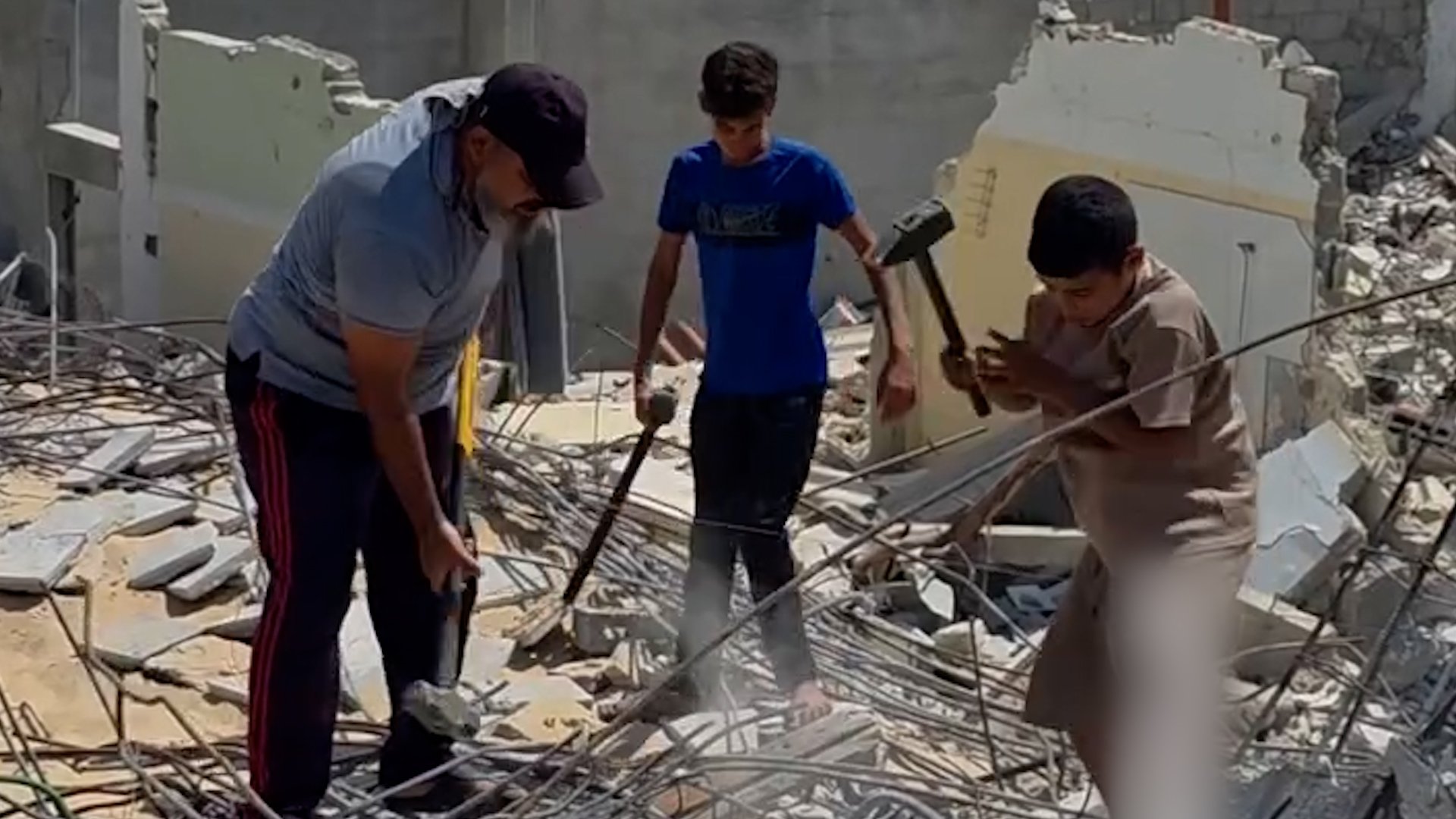 Palestinian father and sons clearing rubble in Gaza amid ongoing Israeli military campaign August 2026