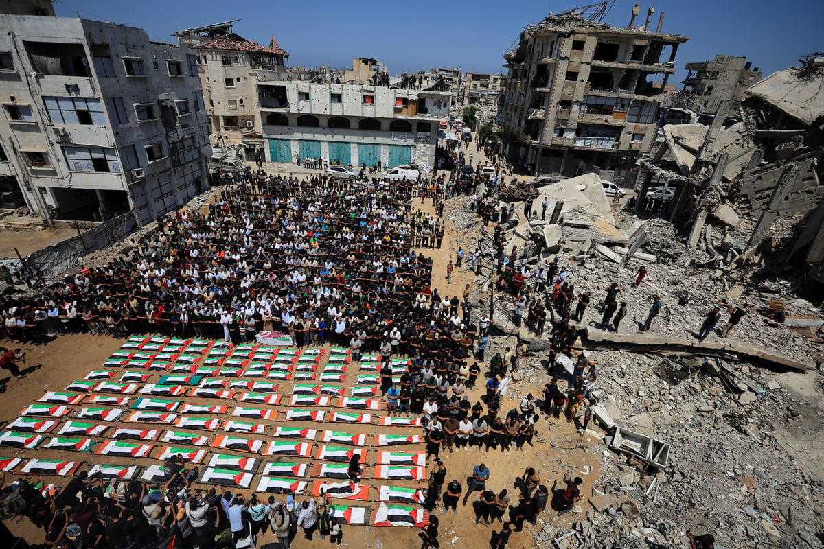 Palestinians carry coffins of 112 members of the Hassayna and Abu Sharia clans killed in an Israeli airstrike in Sabra Gaza City in 2023 during a mass funeral on August 4 2026