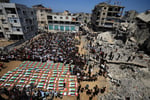 Palestinians carry coffins of 112 members of the Hassayna and Abu Sharia clans killed in an Israeli airstrike in Sabra Gaza City in 2023 during a mass funeral on August 4 2026
