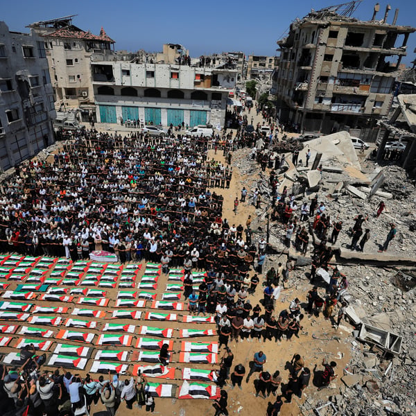 Palestinians carry coffins of 112 members of the Hassayna and Abu Sharia clans killed in an Israeli airstrike in Sabra Gaza City in 2023 during a mass funeral on August 4 2026