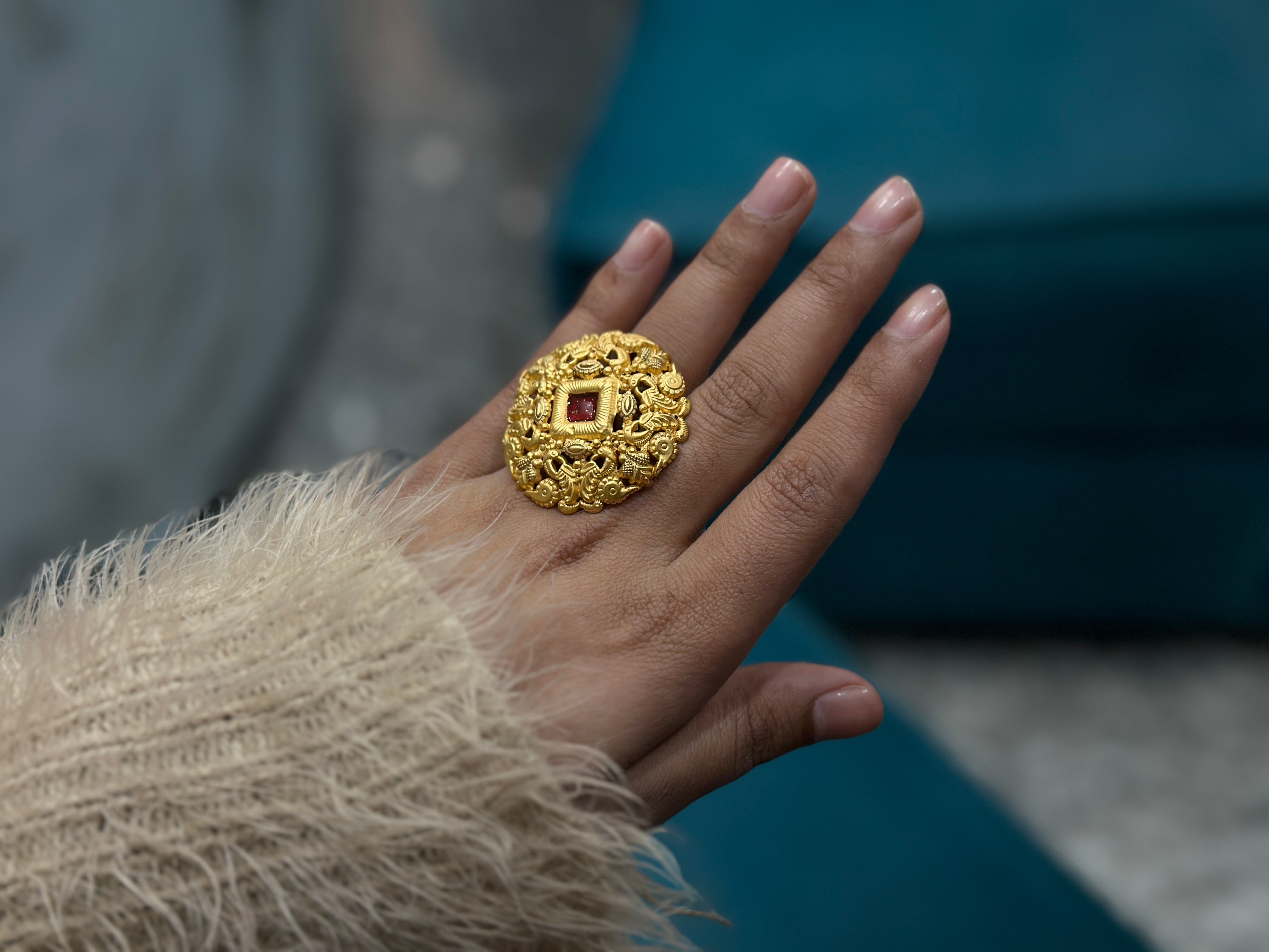 A woman wears a large one gram gold ring, the lighter jewellery Indian buyers turn to at the gold rate today