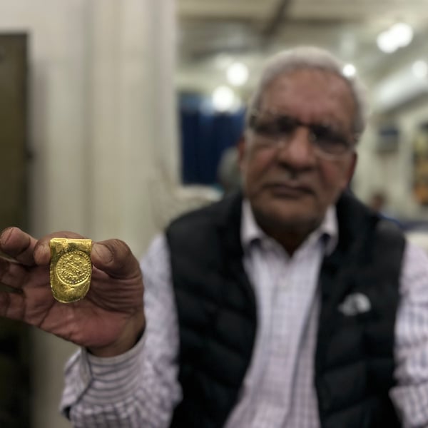 A goldsmith in Srinagar holds a bar of pure gold as the gold rate today holds at Rs 16,309 a gram for 24K