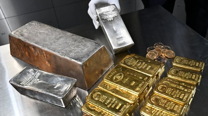 One kilogram gold bars stamped 999.9 fine alongside silver bars and coins, the bullion form behind the 24 carat gold rate today