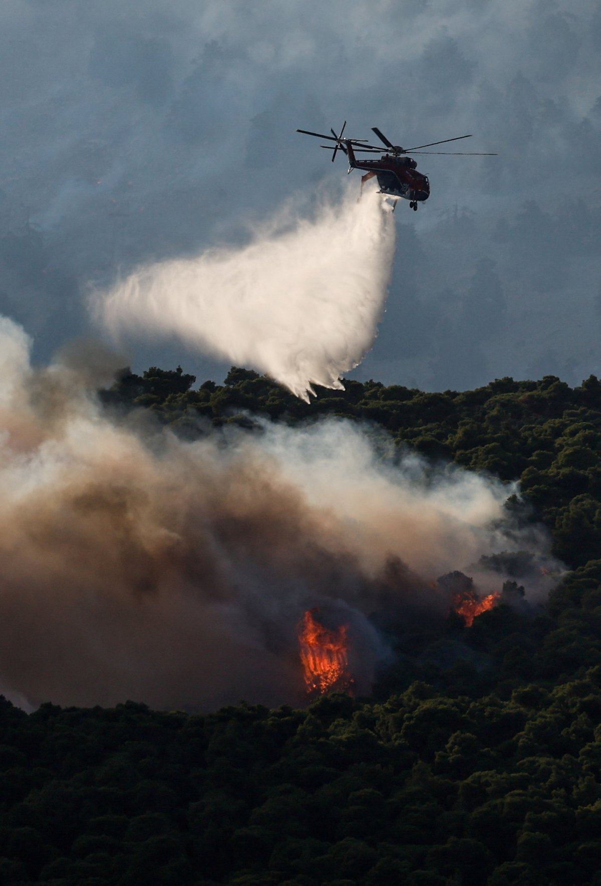 Firefighting helicopter drops water over wildfire smoke billowing near Porto Germeno resort along the Gulf of Corinth in Greece, August 2026
