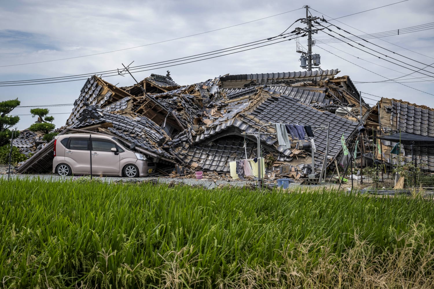 A house collapsed onto a car in Hikawa, Kumamoto Prefecture, following the magnitude 7.1 earthquake on July 30, 2026.