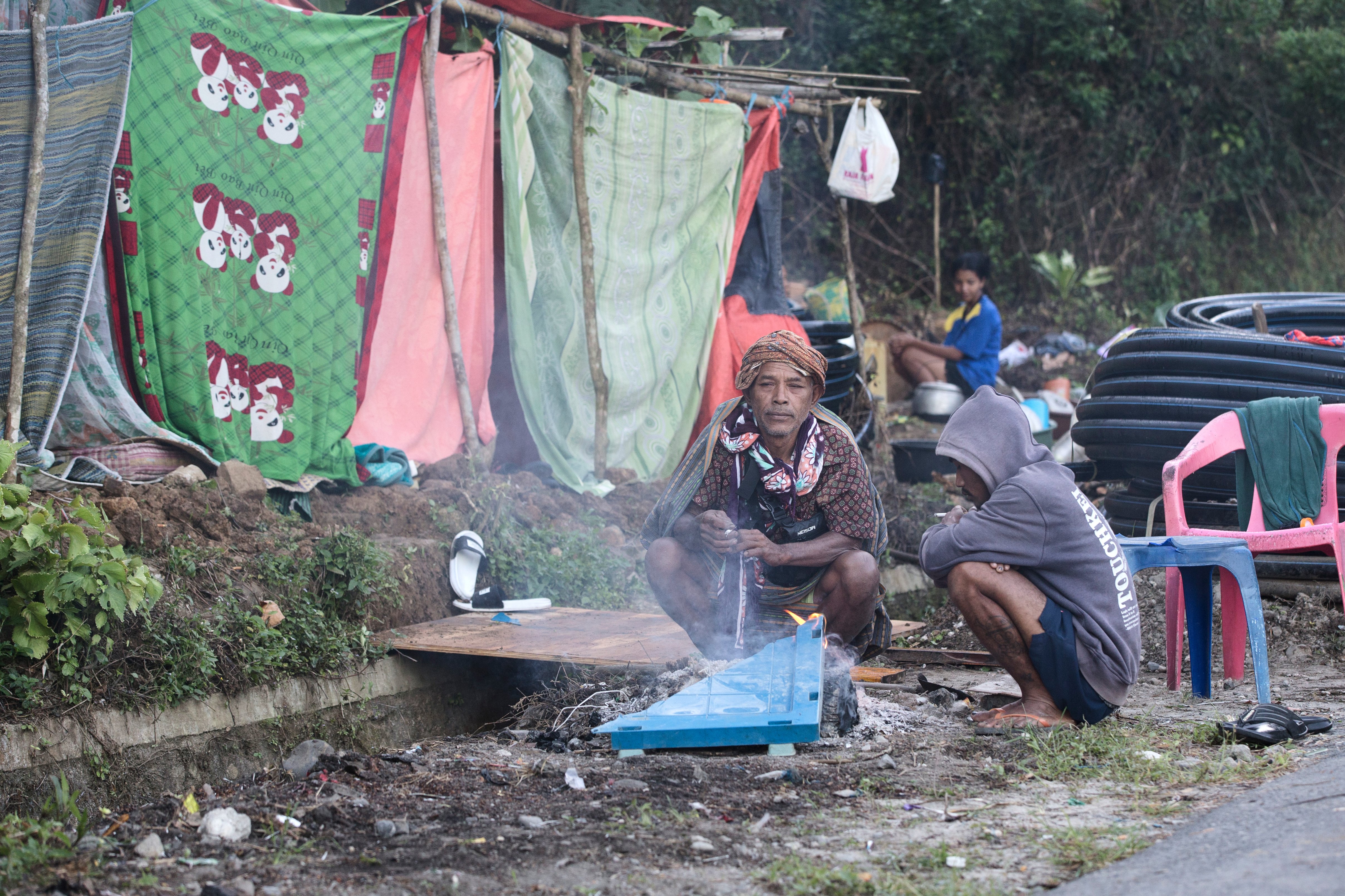 Displaced residents shelter outside a makeshift tent in Reo East Nusa Tenggara after the Indonesia Flores earthquake killed 65 people