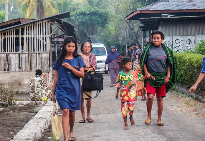 Residents evacuate along a road following the magnitude 7.7 earthquake off Flores Island, Indonesia