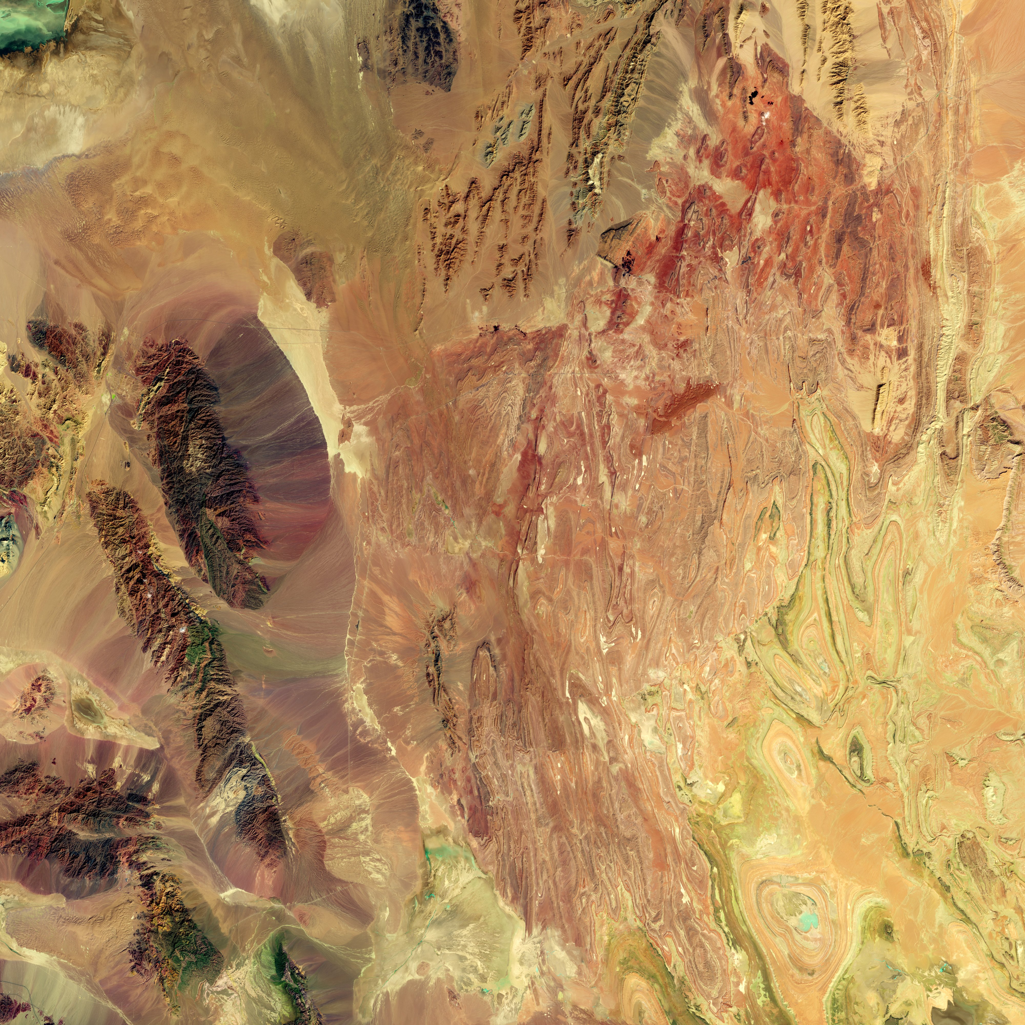 NASA Landsat 8 false-color satellite image showing the arid landscape of central Iran in vivid shortwave infrared colors, revealing the country's vast desert terrain