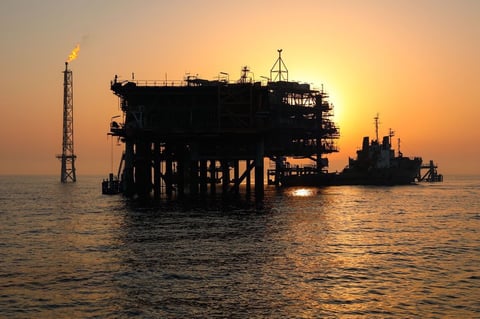 Iranian offshore oil platform in the Persian Gulf at sunset with gas flare