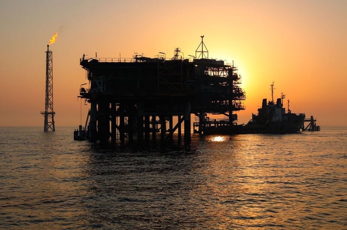 Iranian offshore oil platform in the Persian Gulf at sunset with gas flare