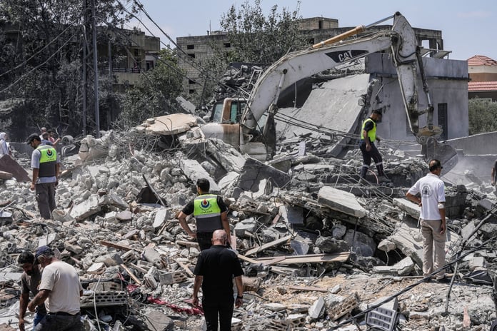 People and rescue workers gather at a destroyed house in Deir al-Zahrani in southern Lebanon after Israeli airstrike August 2026