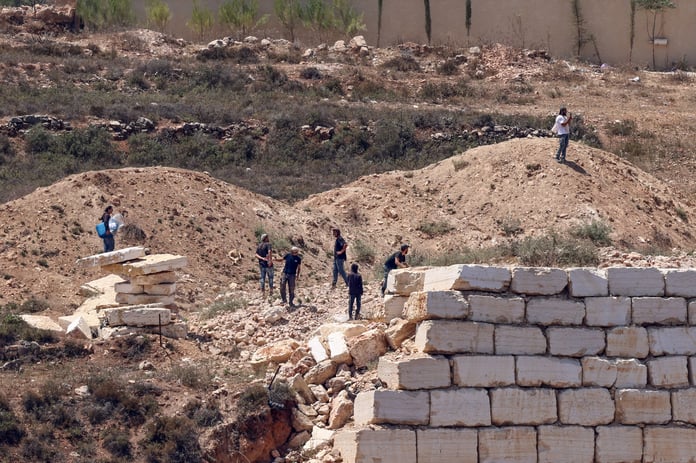 Israeli settlers gathered outside Palestinian homes blockaded in Qusra village south of Nablus in the West Bank