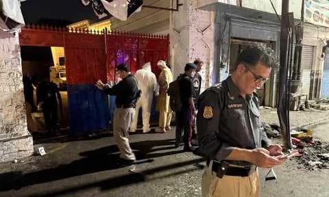 Police officials inspect the site of a suicide bombing at Kabal police station in Swat district Pakistan