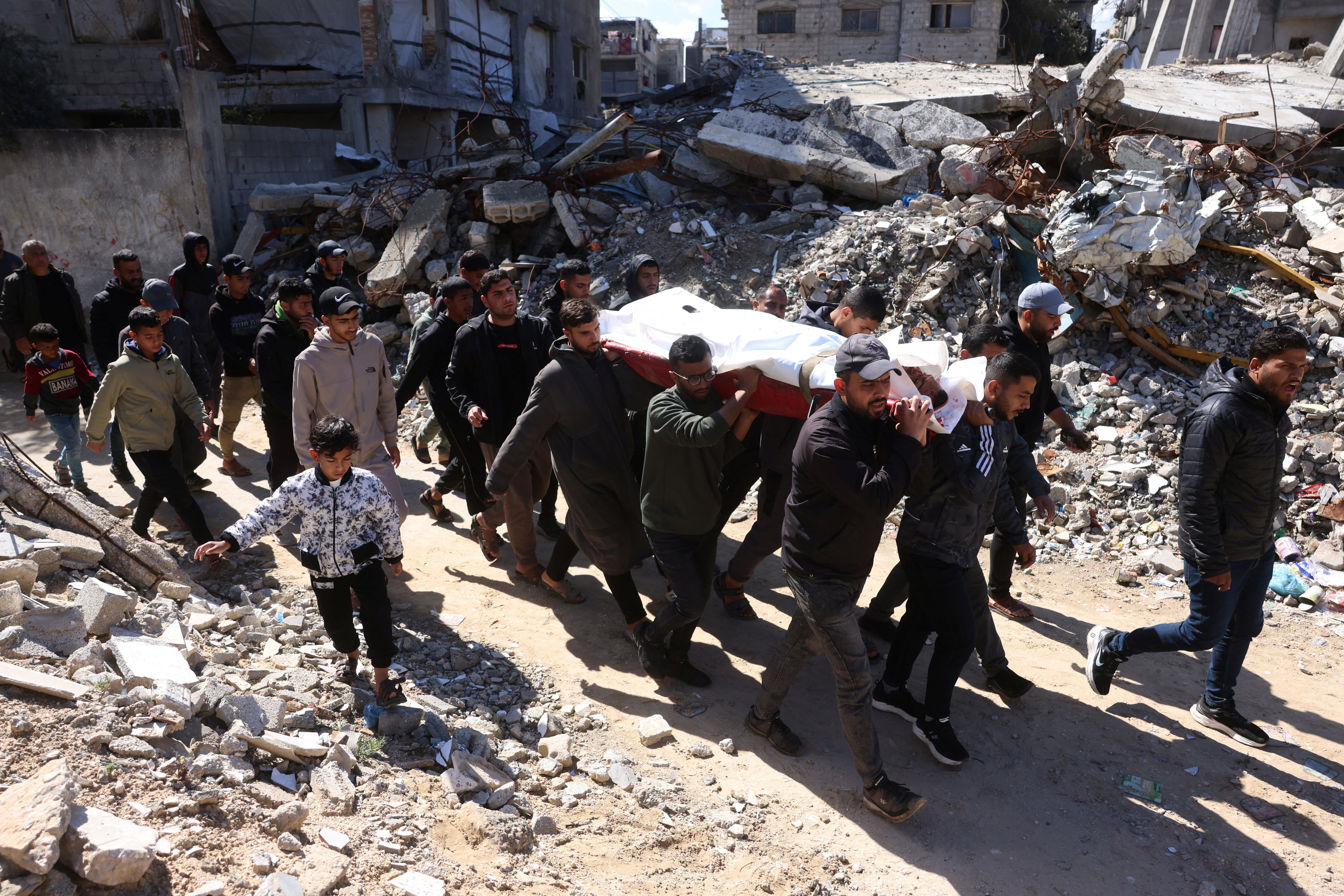 Palestinians carry the body of a person killed in an Israeli military attack in Khan Younis in the southern Gaza Strip