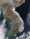 NASA MODIS satellite image showing the Korean Peninsula covered in heavy snow in February 2011, with South Korea's coastal regions and mountain ranges clearly visible from space