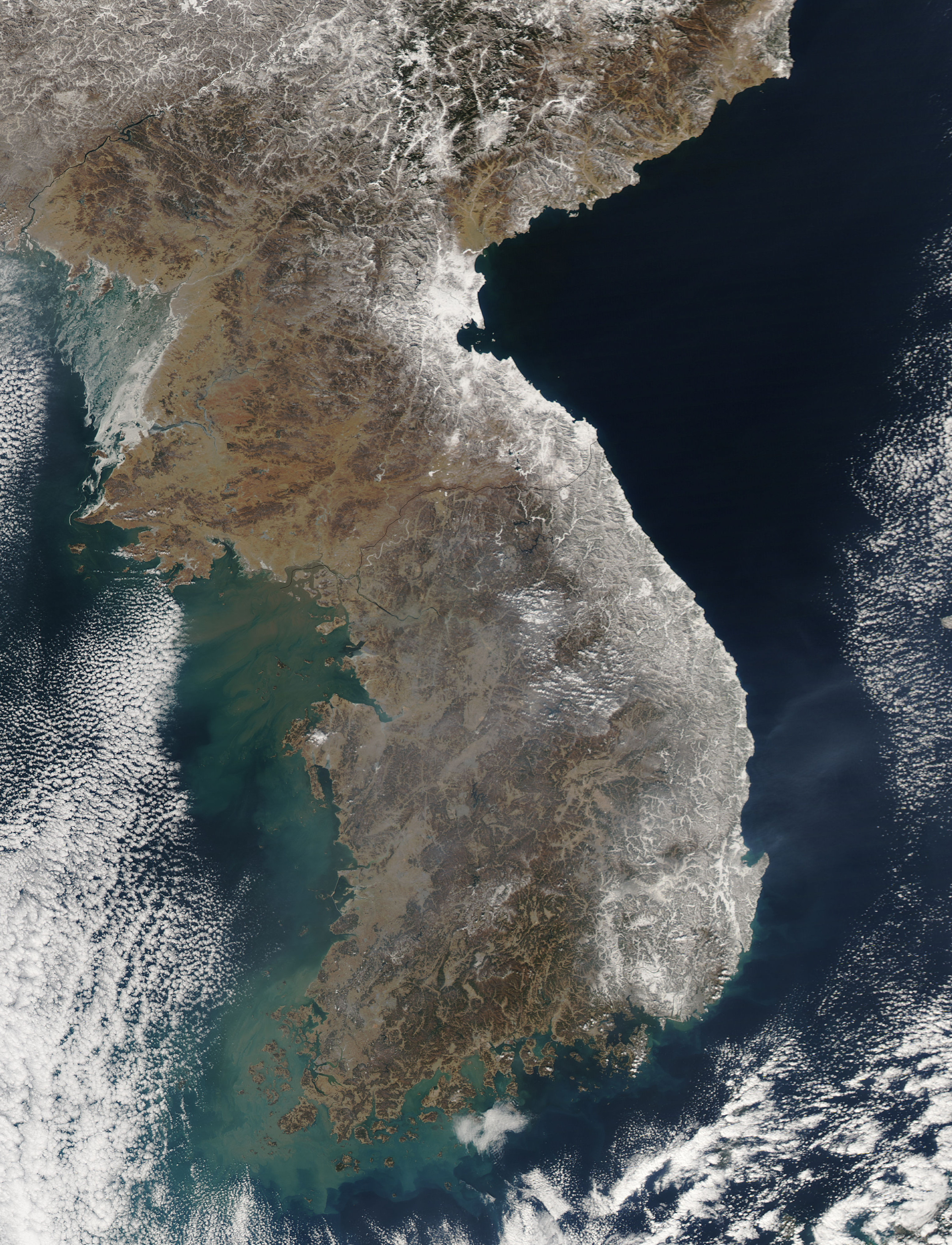 NASA MODIS satellite image showing the Korean Peninsula covered in heavy snow in February 2011, with South Korea's coastal regions and mountain ranges clearly visible from space