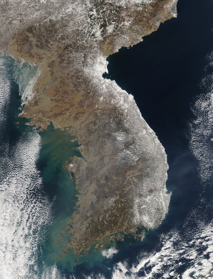 NASA MODIS satellite image showing the Korean Peninsula covered in heavy snow in February 2011, with South Korea's coastal regions and mountain ranges clearly visible from space