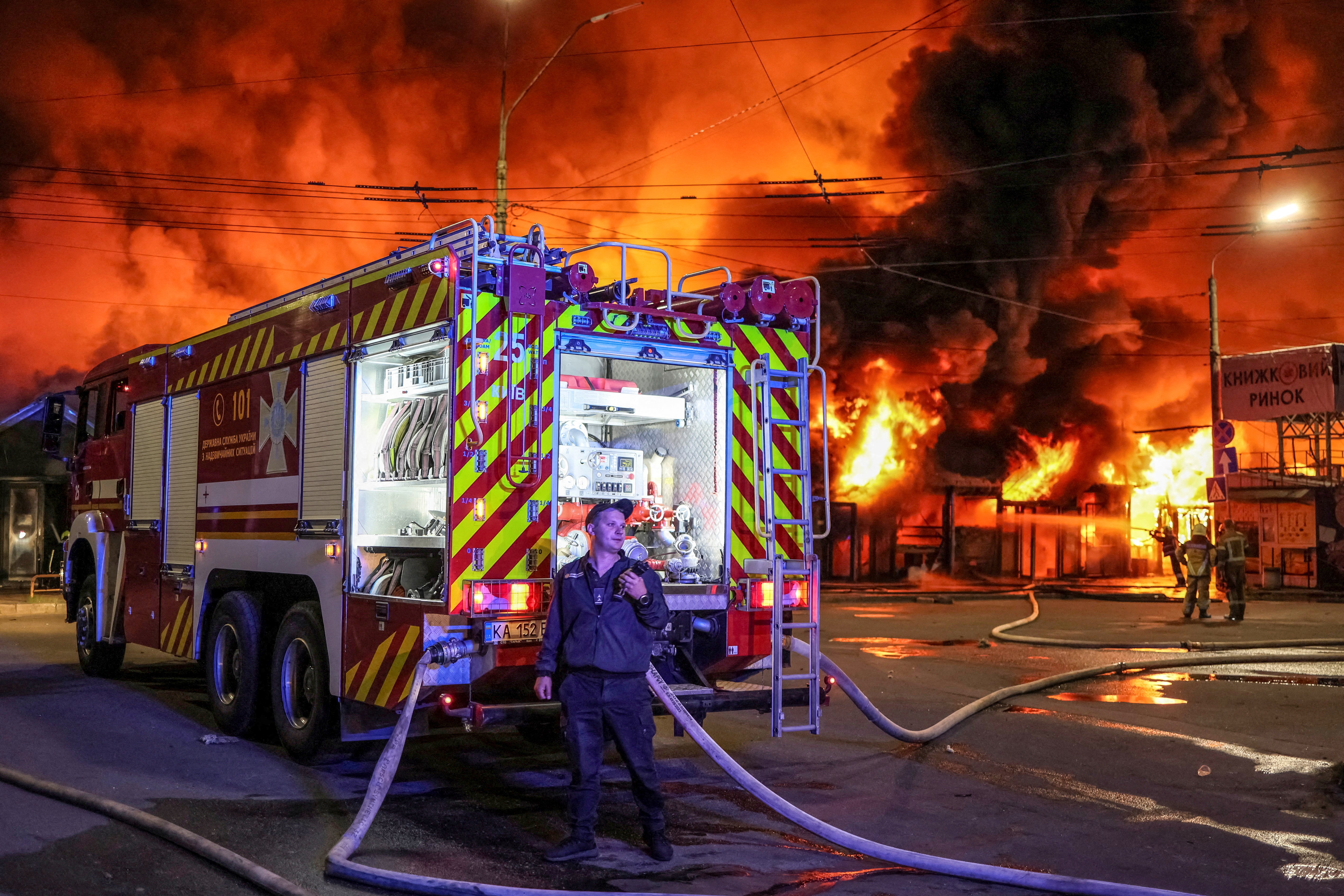 Firefighters work at a Kyiv book market destroyed by a Russian missile strike on August 16, 2026