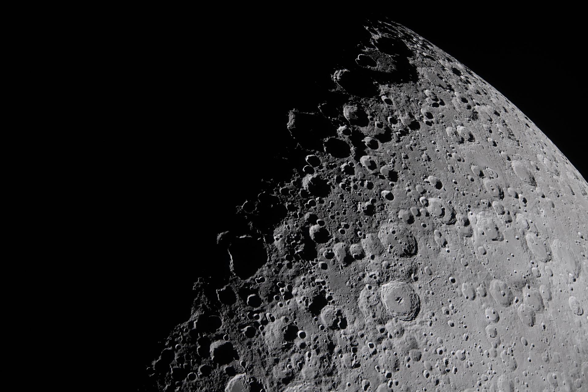 Low-angle sunlight along the lunar terminator casts long shadows across craters and ridges on the Moon's surface in an Artemis II crew photograph