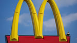 McDonald's golden arches sign against a blue sky, representing the chain's Q2 2026 earnings report showing slowing US same-store sales and a new US president appointment