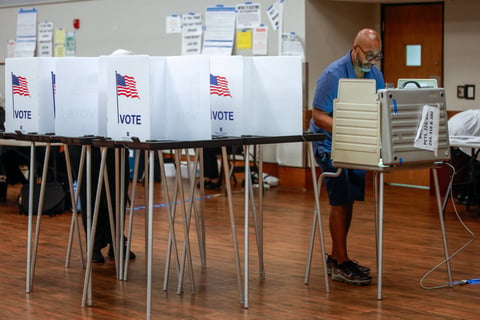 A voter casting ballot at a Detroit polling station during the 2026 Michigan primary election as federal DOJ monitors were deployed to the city