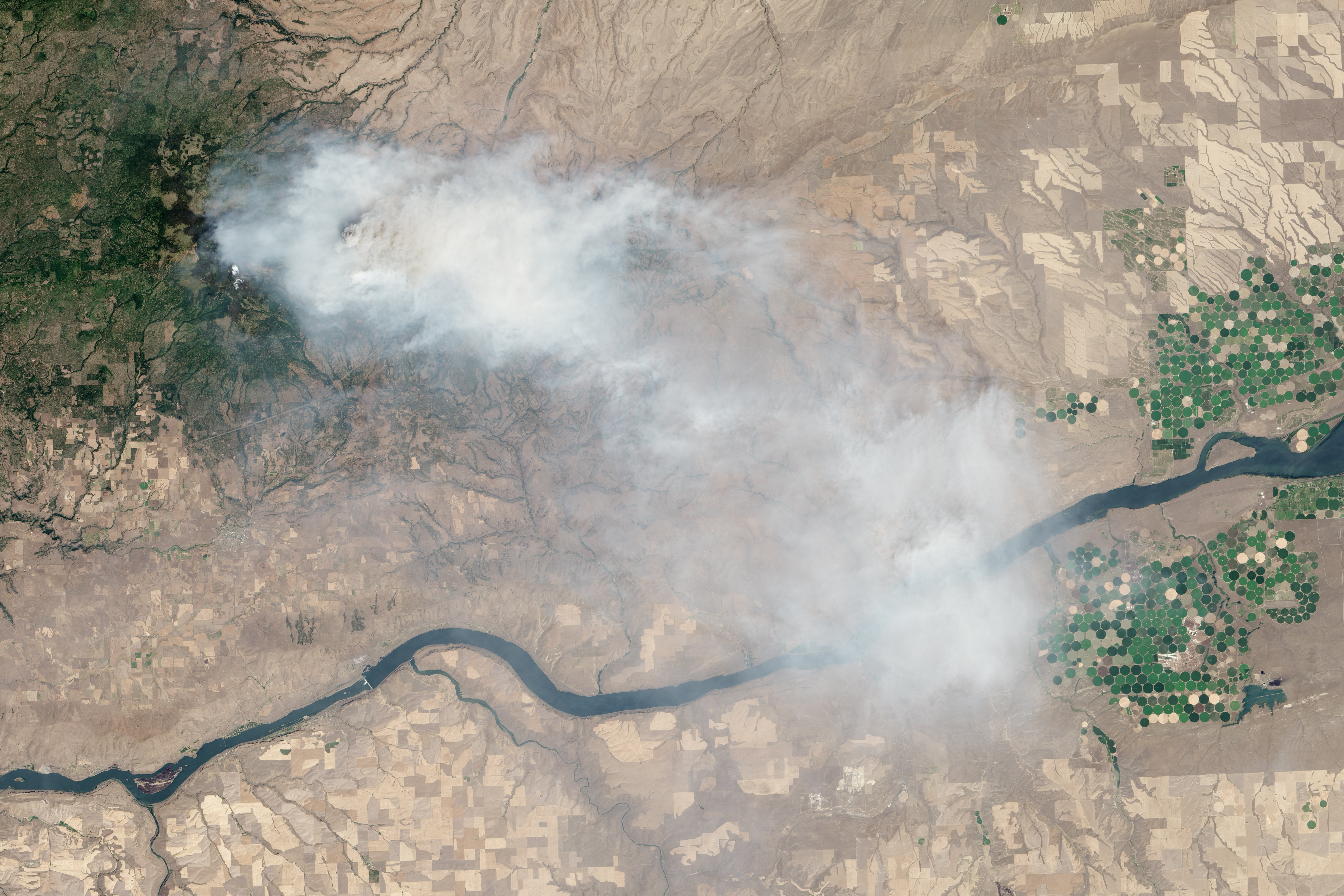 NASA satellite image of the Mile Marker 28 wildfire burning in Washington state Simcoe Mountains sending smoke across the Pacific Northwest