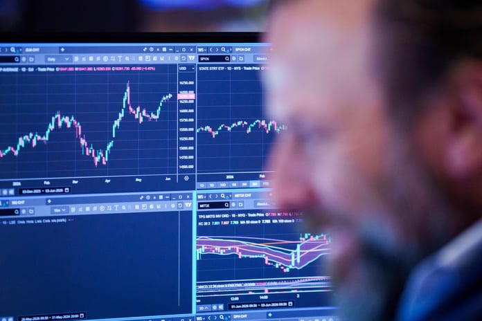 Nasdaq Composite today: a trader watches screens showing index and equity price charts