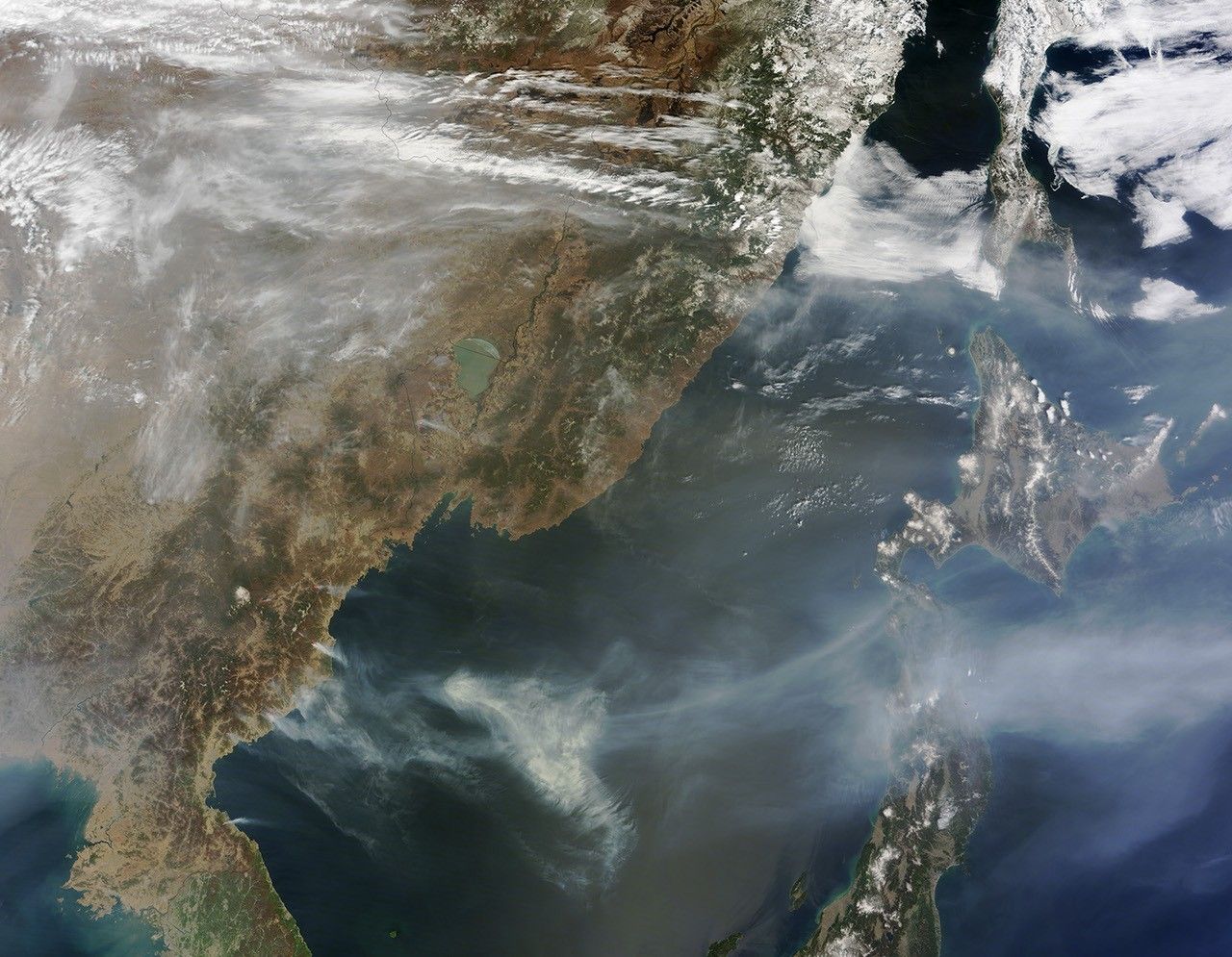 NASA MODIS satellite image showing North Korea from above with agricultural fires burning in the eastern countryside, the Sea of Japan visible to the right