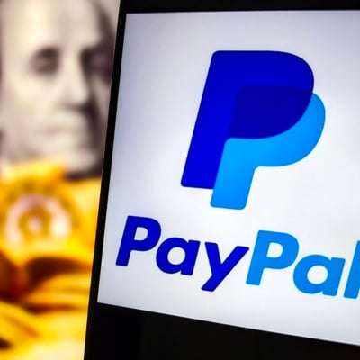 PayPal app logo on a smartphone against a background of US currency, representing the company's digital payments business and $53 billion acquisition talks with Stripe
