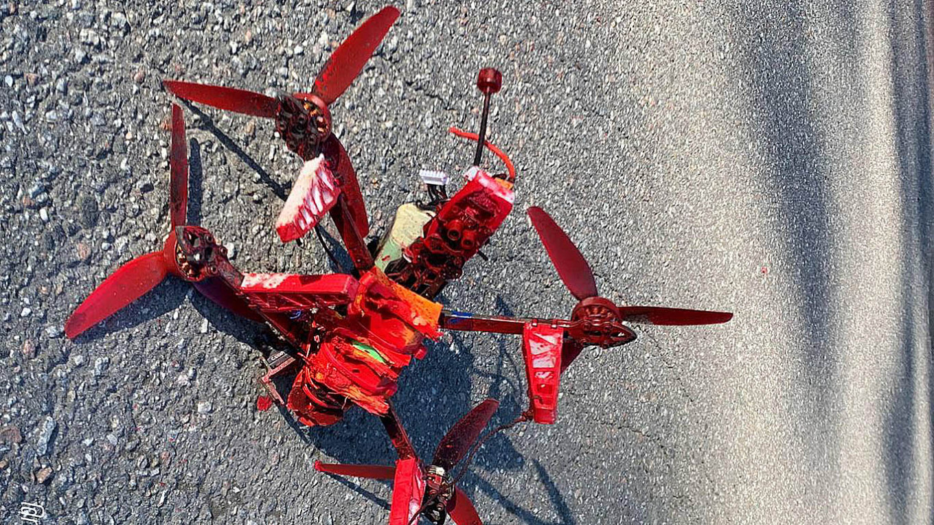 A second small drone thickly coated in red paint lying on asphalt after an attack on a Russian diplomatic property in Stockholm