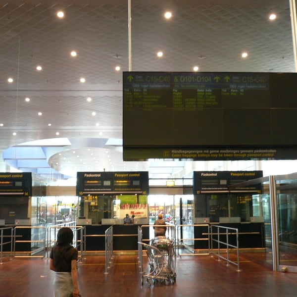 Passengers at border control booths in a Schengen airport terminal