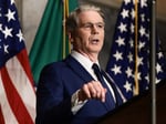 US Treasury Secretary Scott Bessent points while speaking at a podium in front of American flags and the Treasury Department flag